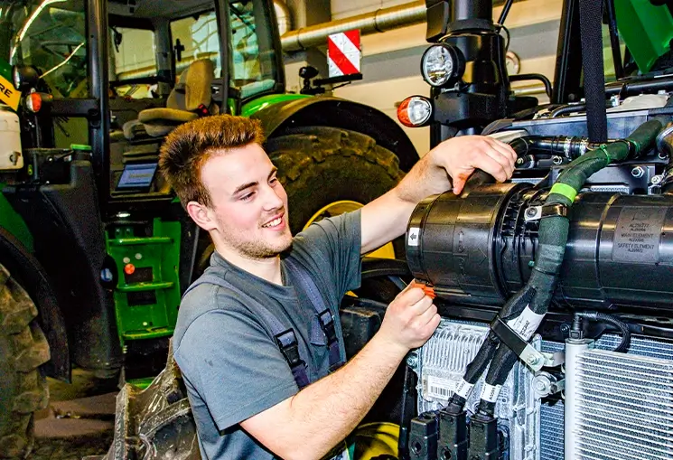Azubi Mechatroniker arbeitet am Gerät in Werkstatt