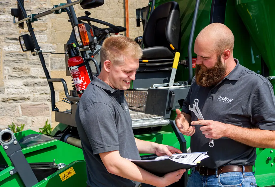 2 Männer fachsimpeln, in den Händen Werkzeug