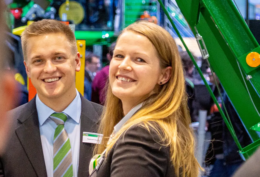 Mann und Frau in Firmenkleidung auf der Messe