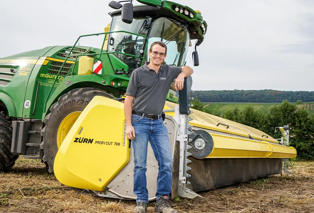 Mann vor Schneidwerk auf dem Feld