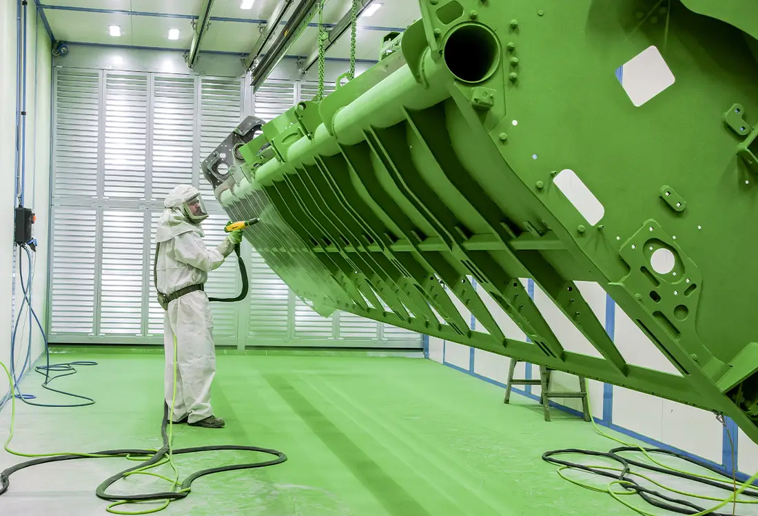 Mann lackiert landwirtschaftliches Gerät im Oberflächenzentrum