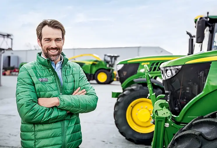 Verkäufer vor Landmaschinen auf dem Standorthof